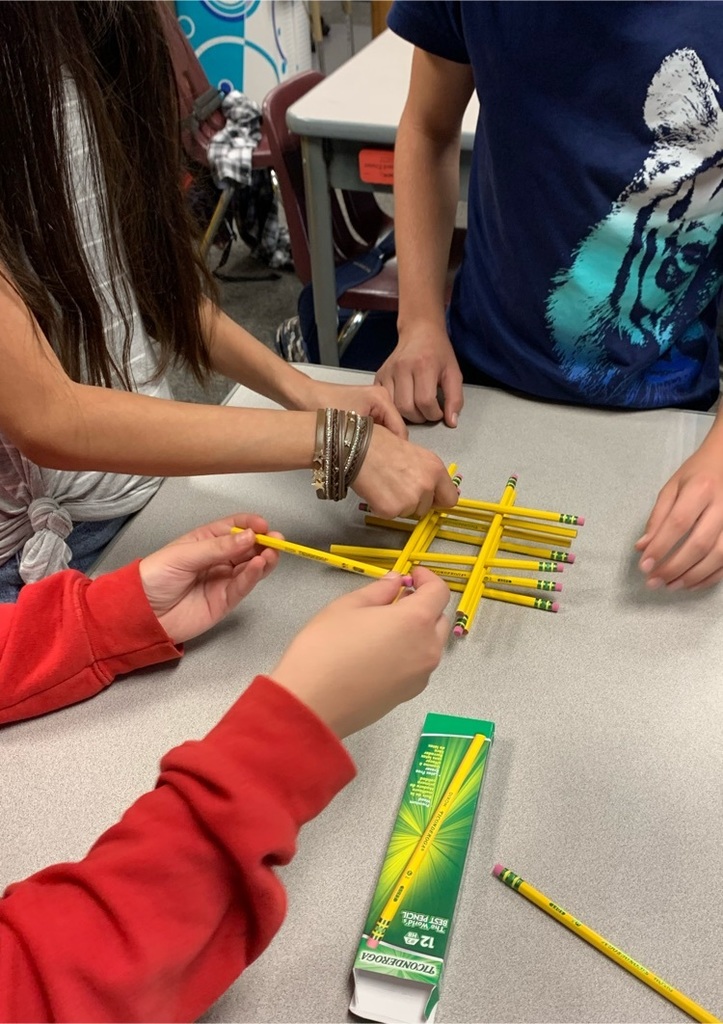 Three students arrange pencils similar to Lincoln Logs
