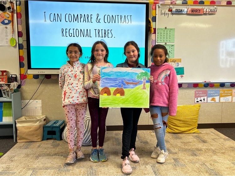 third grade students, holding a poster with a scene of the coast in colored pencil.