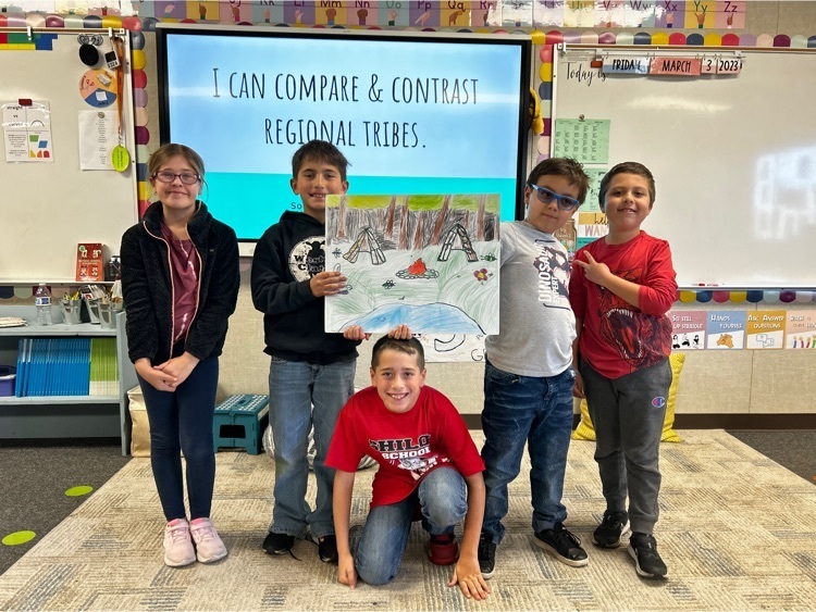 third grade students, holding a poster with a scene of the mountains in colored pencil.