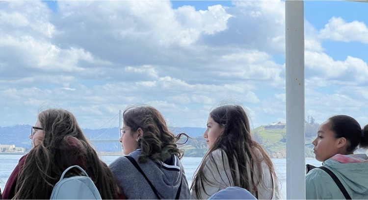 Students looking to left while on a ferry boat