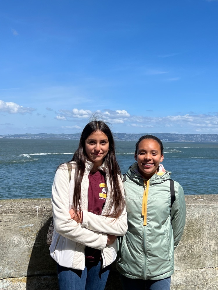 Two students posing for a picture with San Francisco Bay on the background 