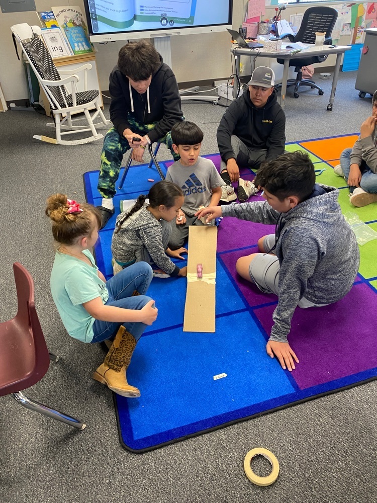 kindergarten and 8th grade students doing an experiment on gravity and speed